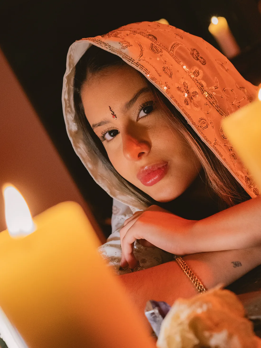 Brielah, con un velo bordado, a la luz de las velas